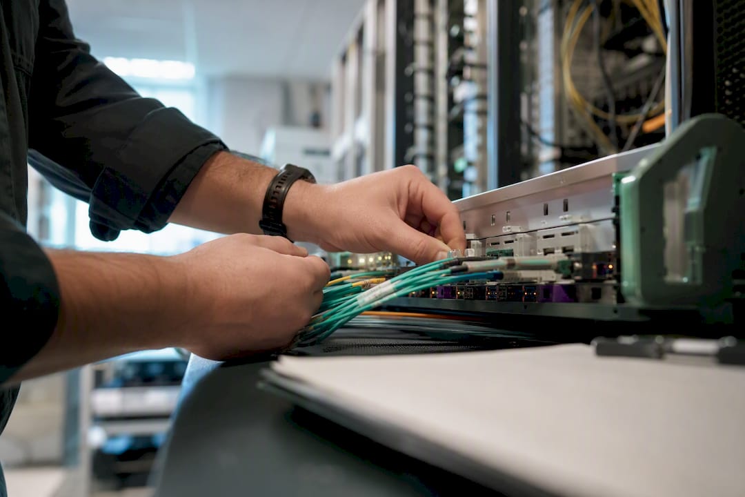 Hands connecting cables in server room