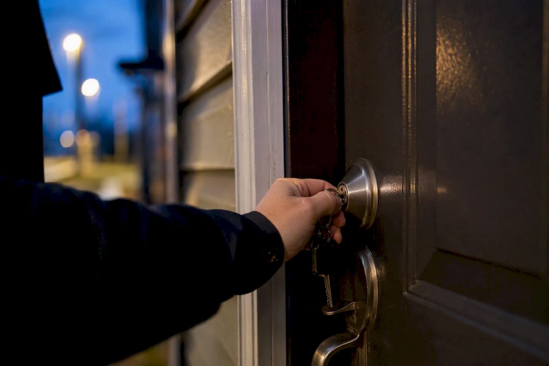 Hand checking door lock on rental unit