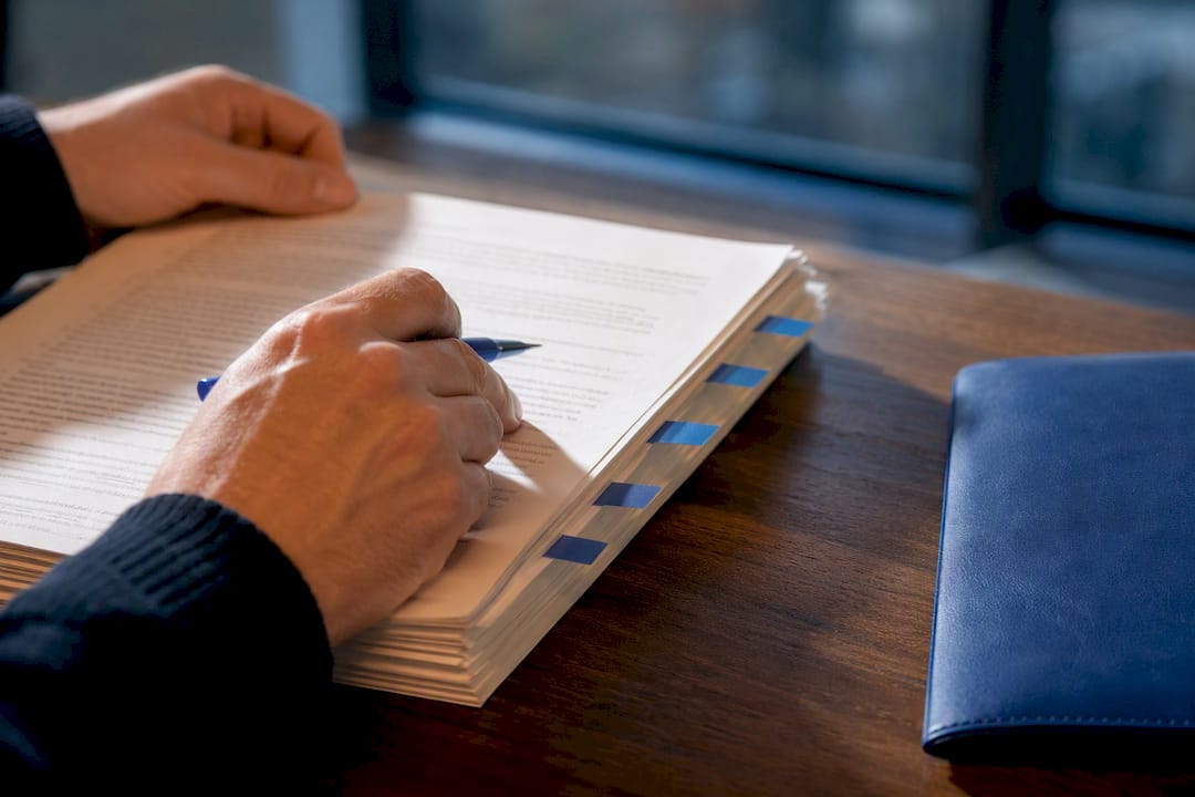 Hands cross-referencing commercial lease clauses