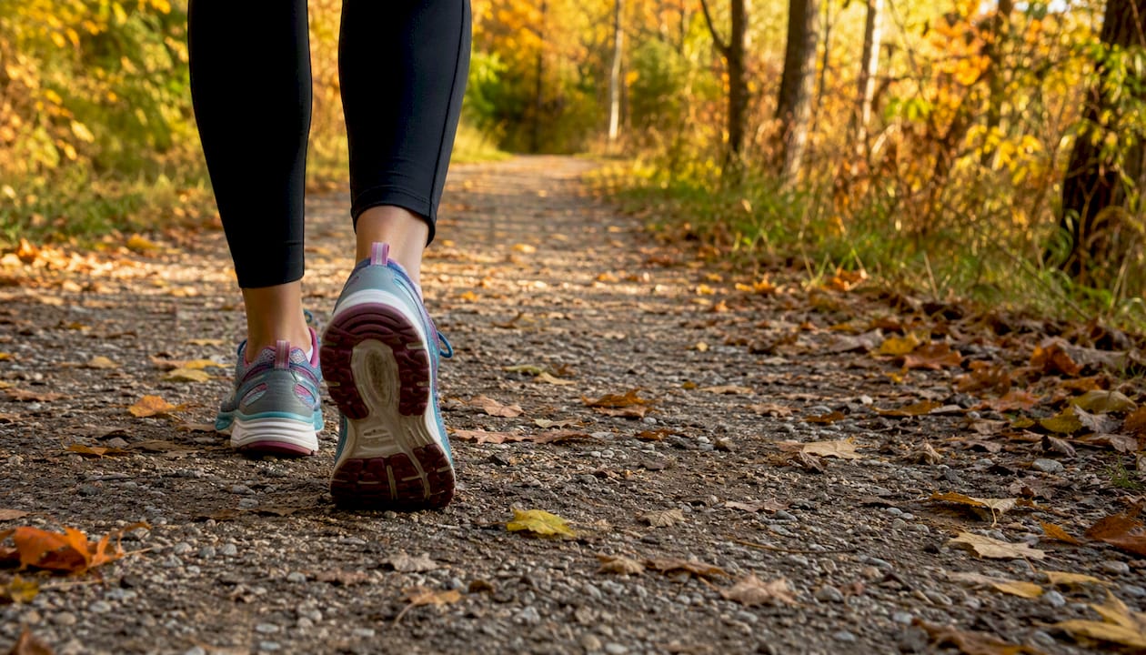 Feet walking briskly on a park path