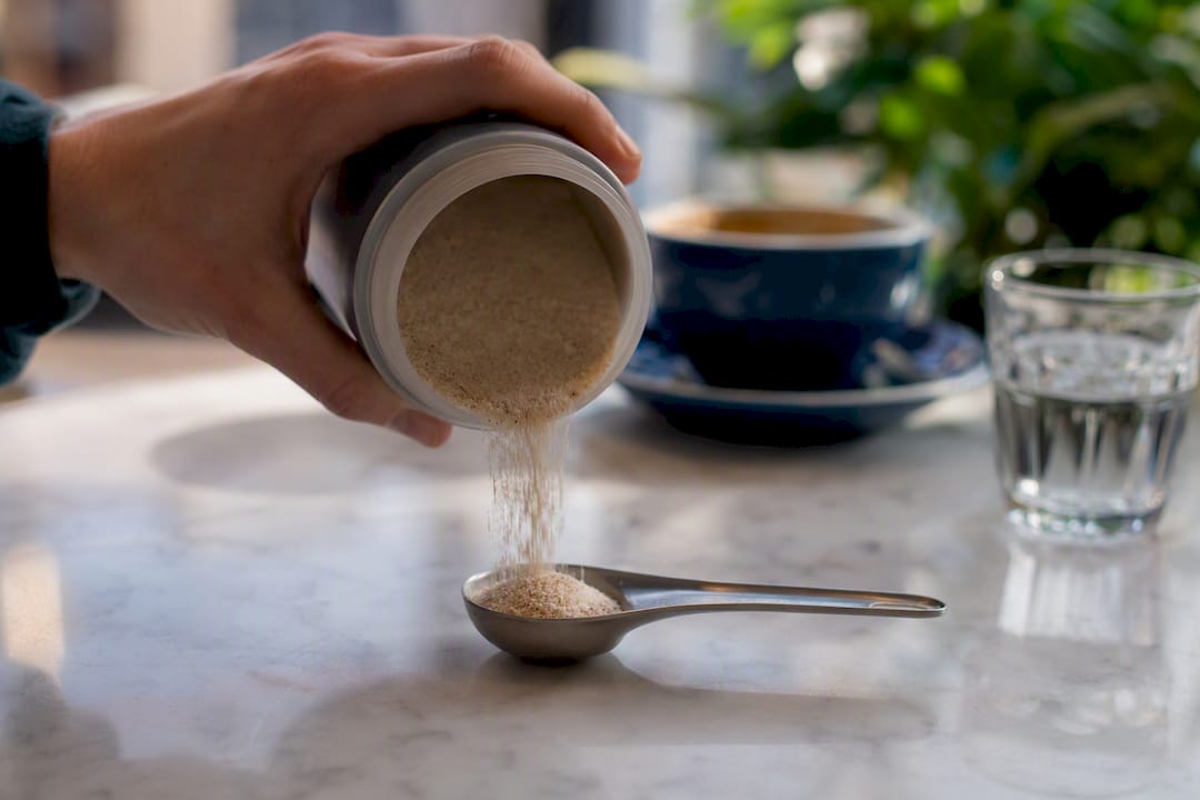 Pouring psyllium powder into measuring spoon