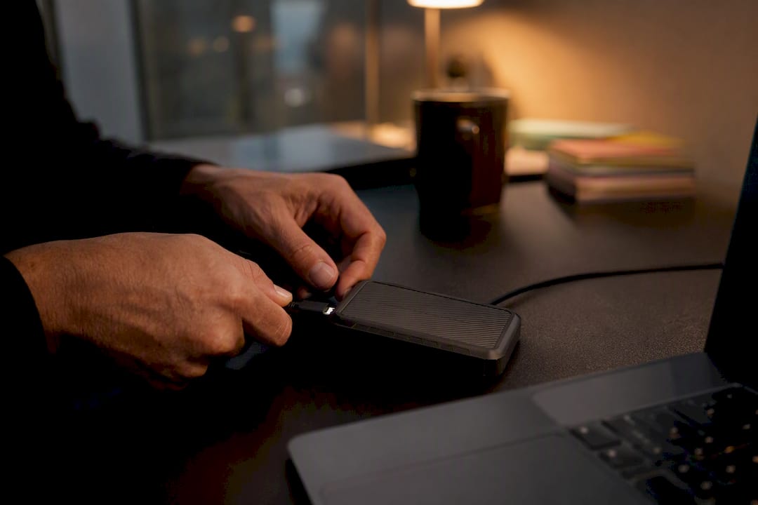 Hands connecting cable to external SSD