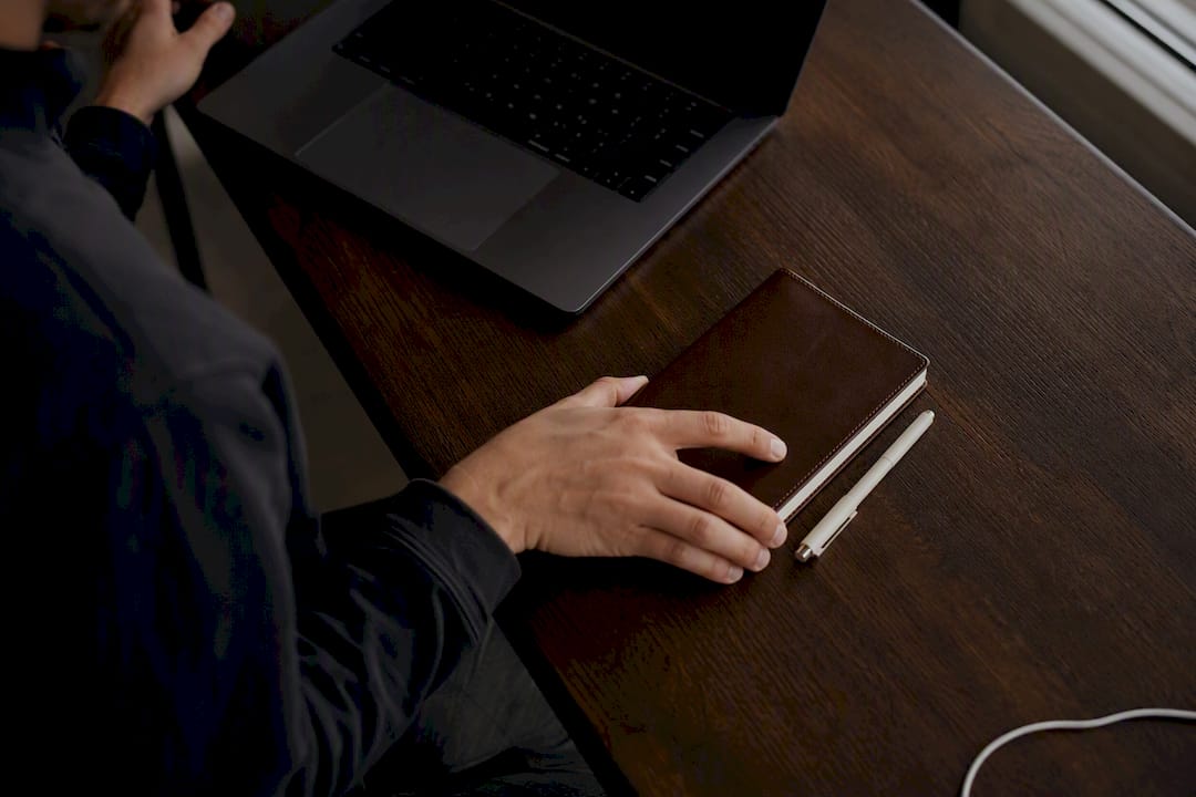 Hand placing notebook on desk
