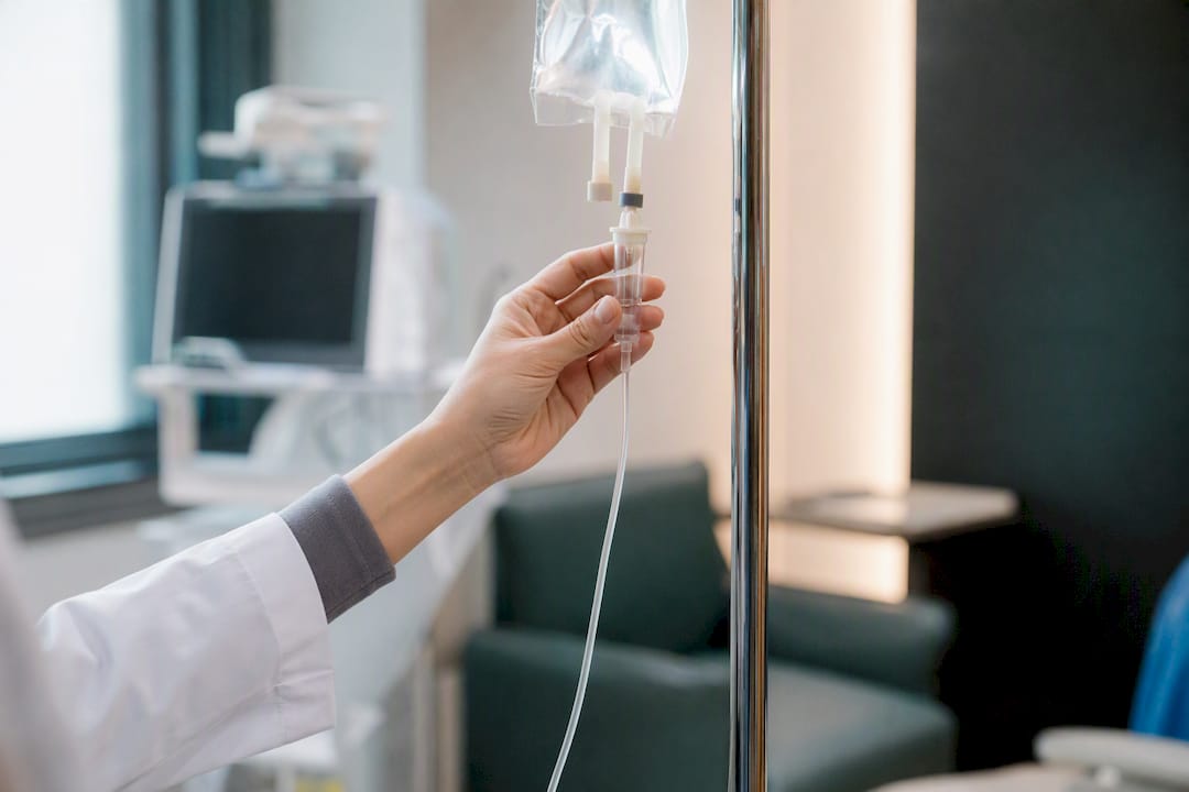 Hand adjusting IV drip rate in clinical setting