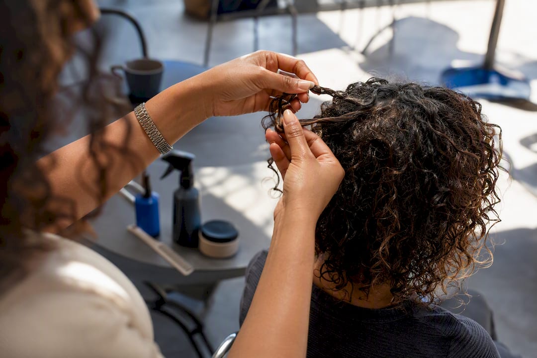 Stylist hands scrunching curly hair