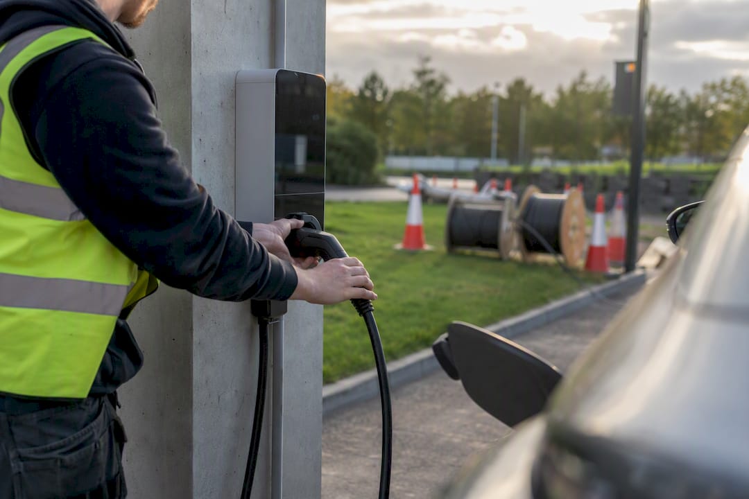 Hands connecting commercial EV charger cable