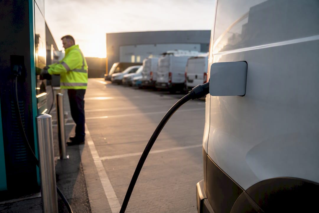Technician connecting EV charger at fleet depot