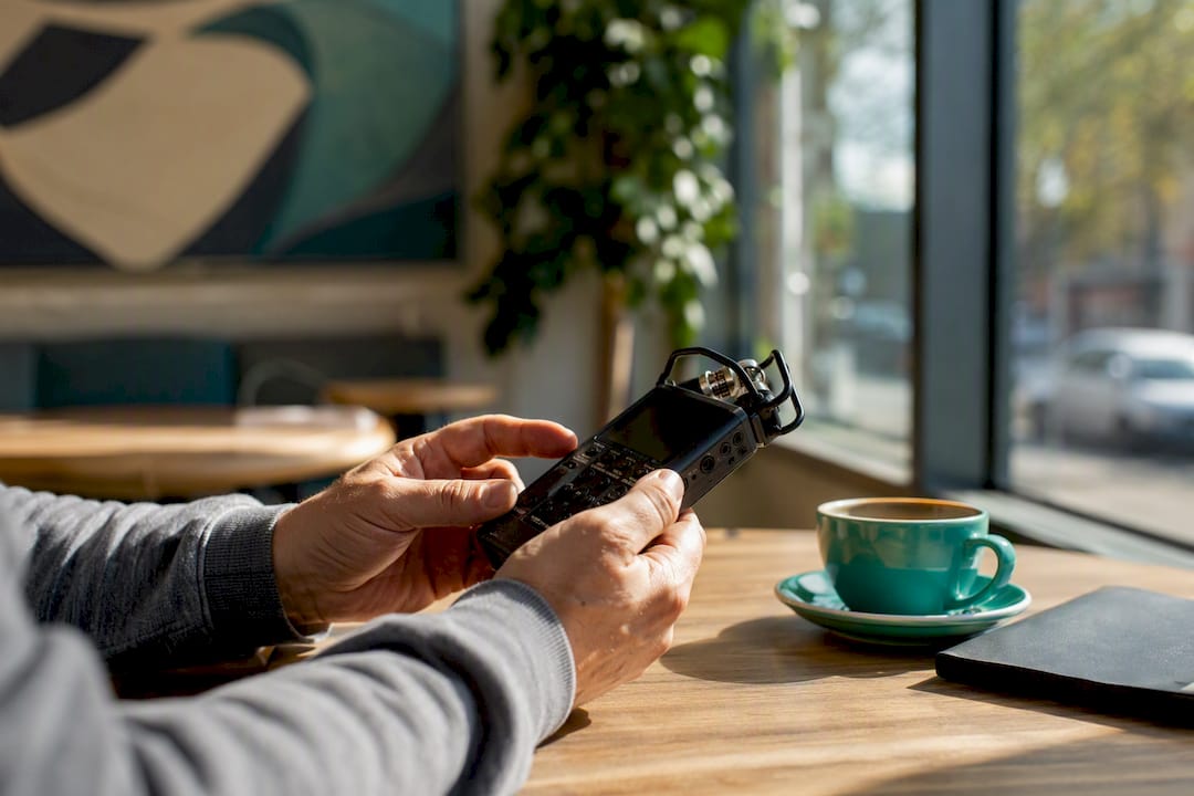 Hands adjusting podcast microphone on desk