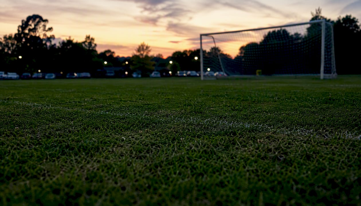 Natural grass soccer field without lights at twilight