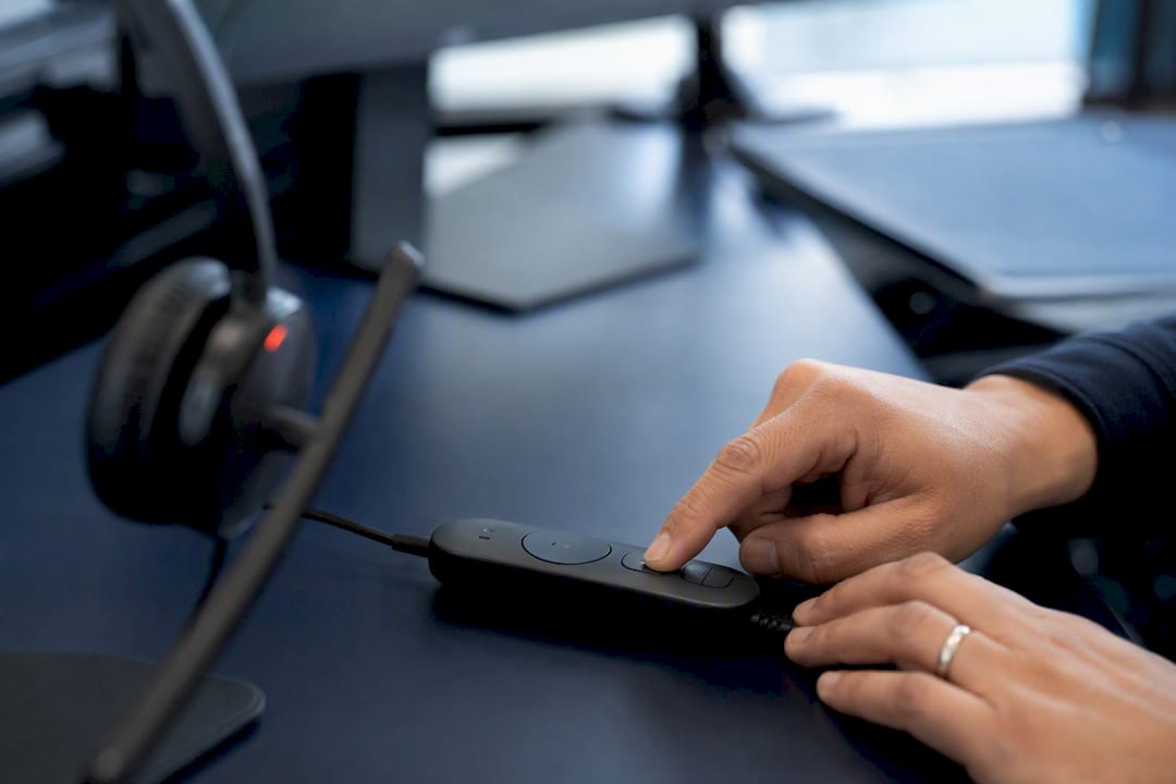Hands pressing headset control button