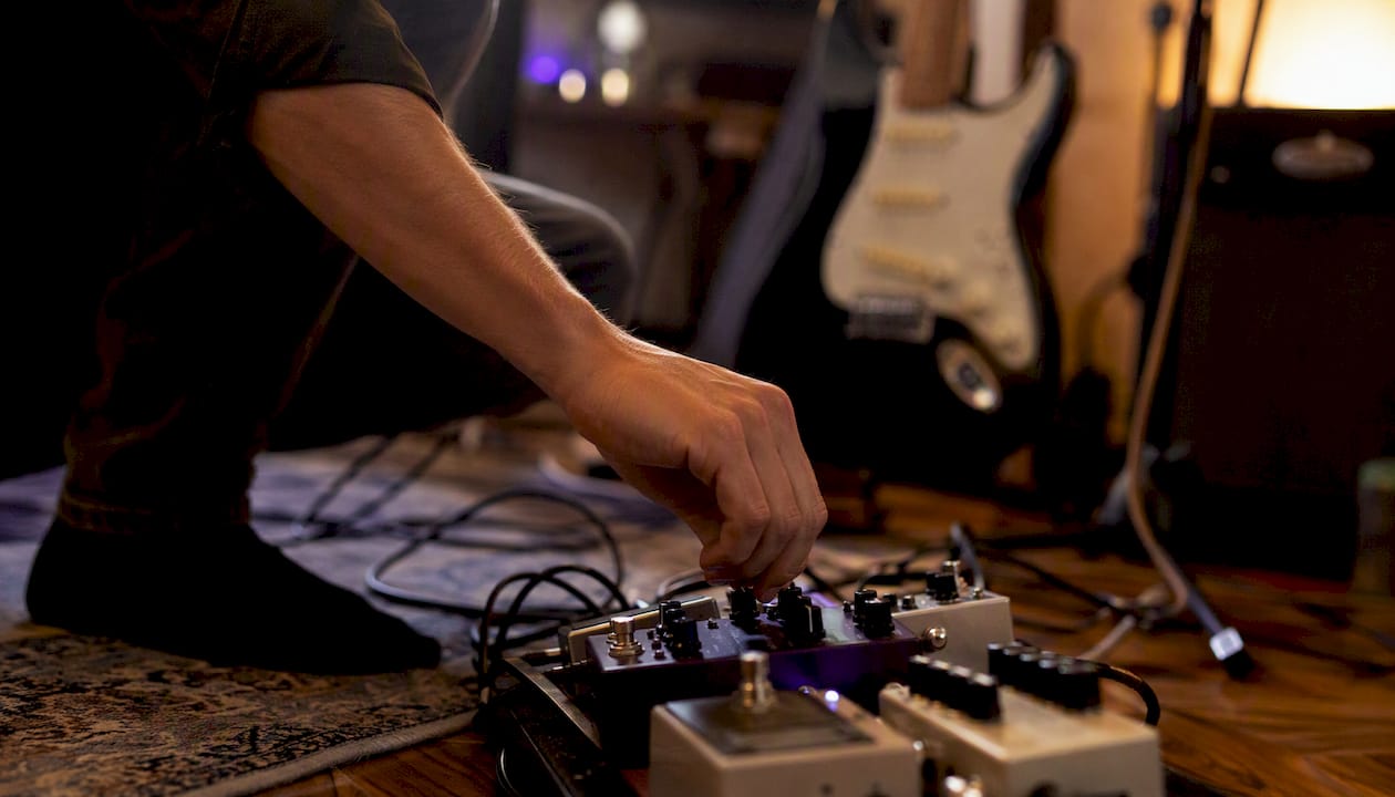 Hand adjusting guitar effects pedal knob