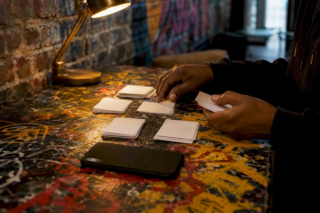 Hands sorting pitch notes for playlist outreach
