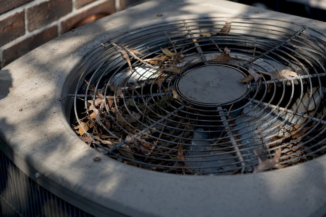 Outdoor AC fan blades obstructed by leaves