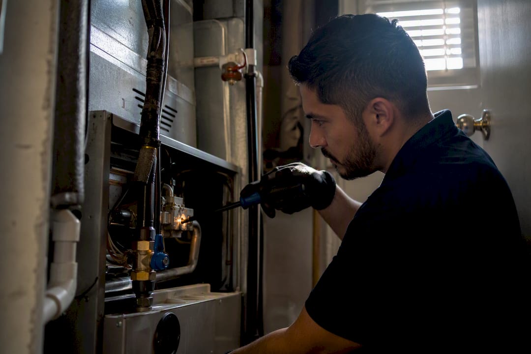 Technician lighting pilot flame in furnace