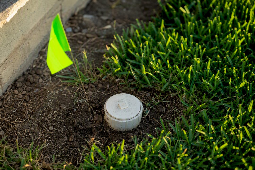 Surveyor flag marking sewer cleanout outdoors