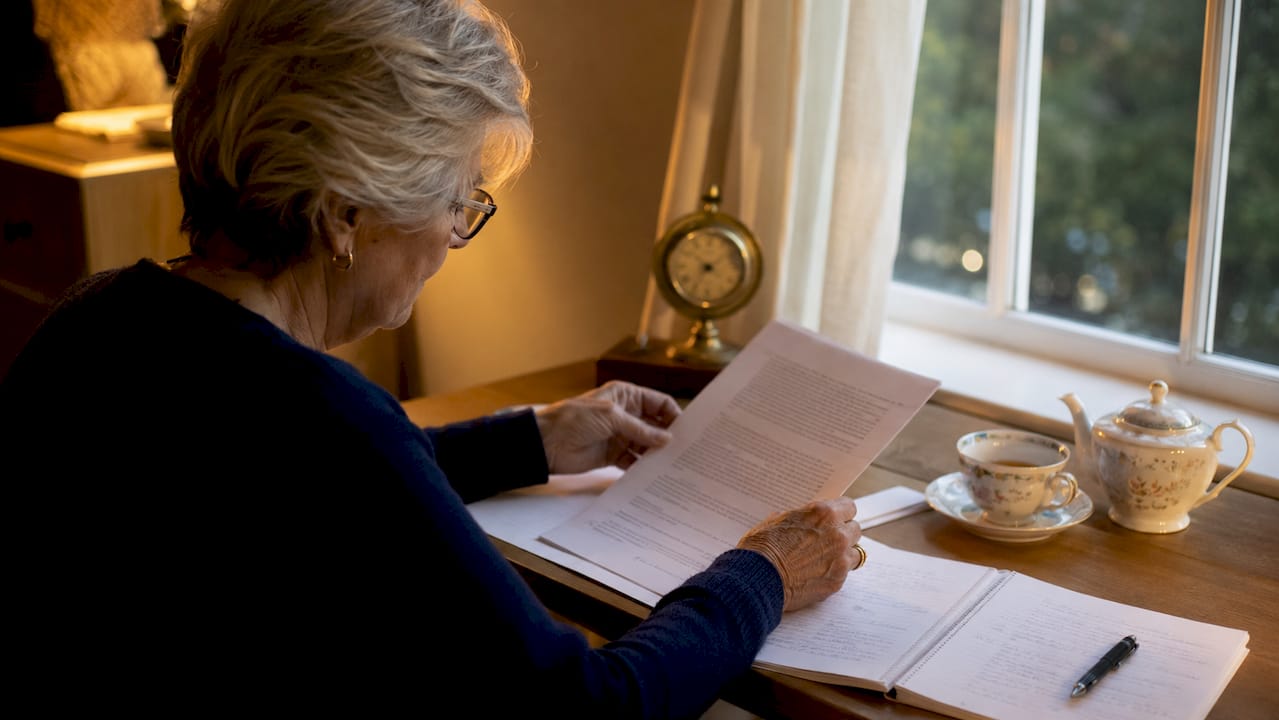 Hands holding Section 8 eviction notice over table