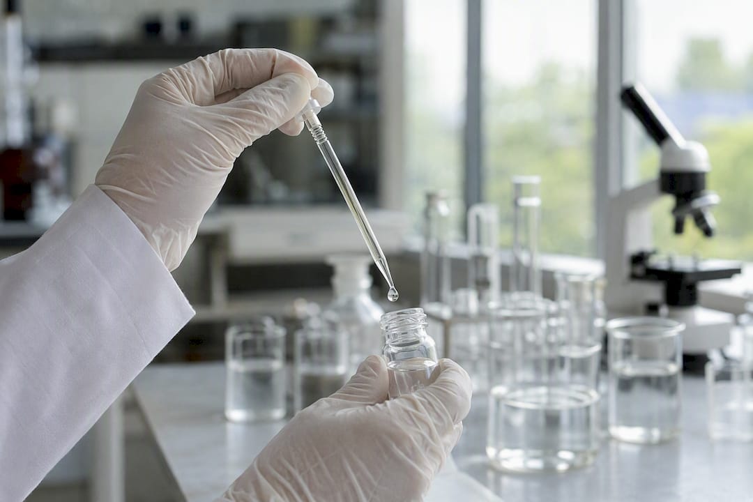 Dans le laboratoire, un sérum à base de mucus d'escargot est versé sur les mains d'un chercheur.