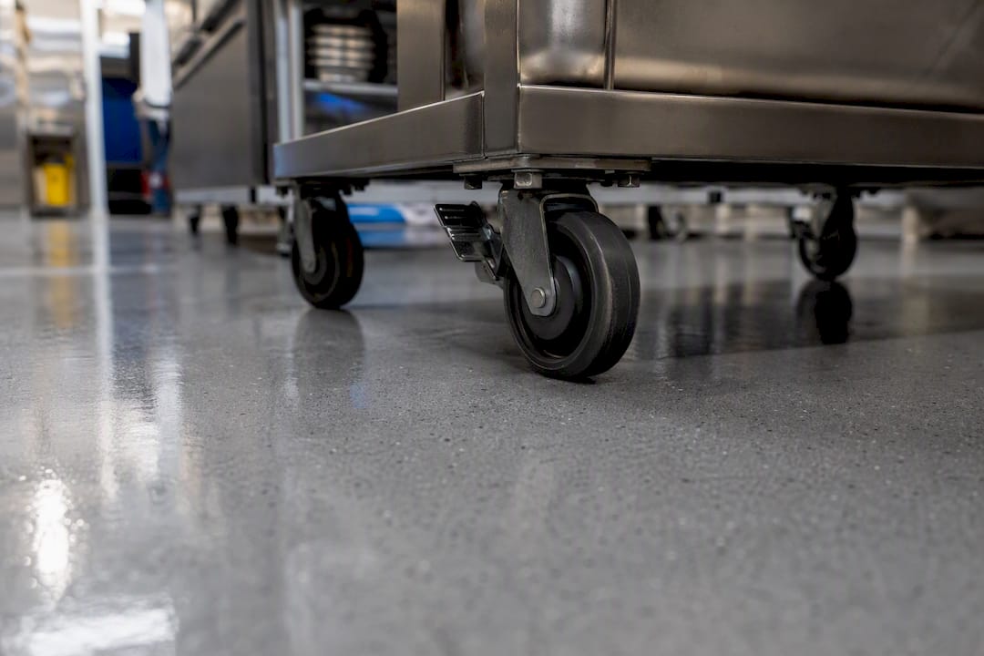 Rubber caster wheels rolling on epoxy kitchen floor