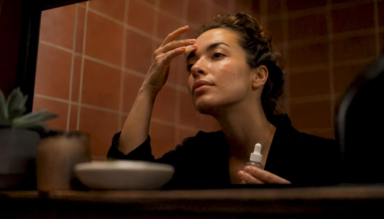 Person applying niacinamide serum to skin