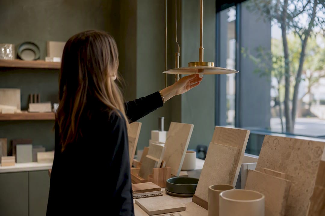 Hand adjusting light fixture sample in showroom