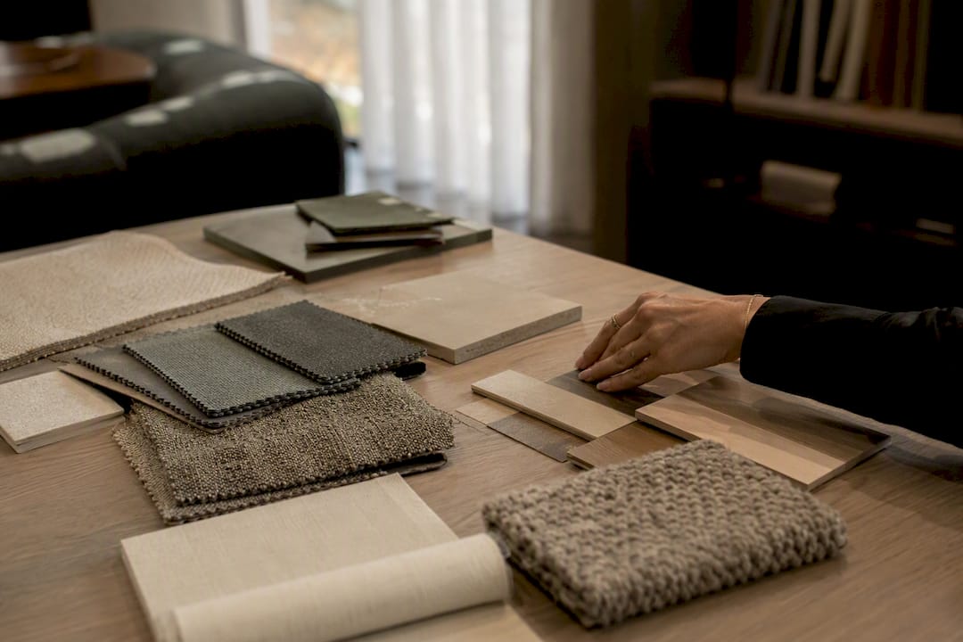 Hands selecting fabric samples in trade showroom