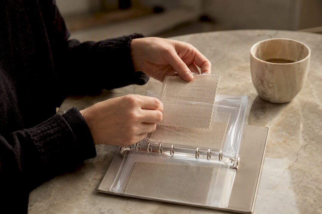 Hands placing fabric swatch in protective sleeve