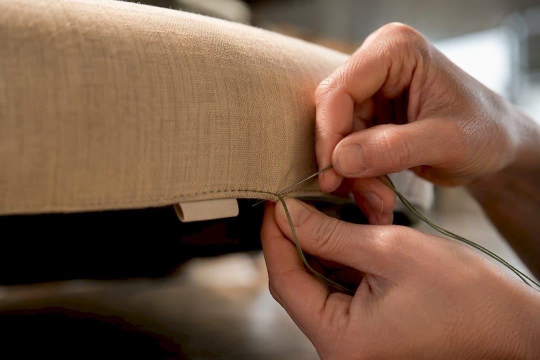 Permanent label sewn beneath upholstery cushion