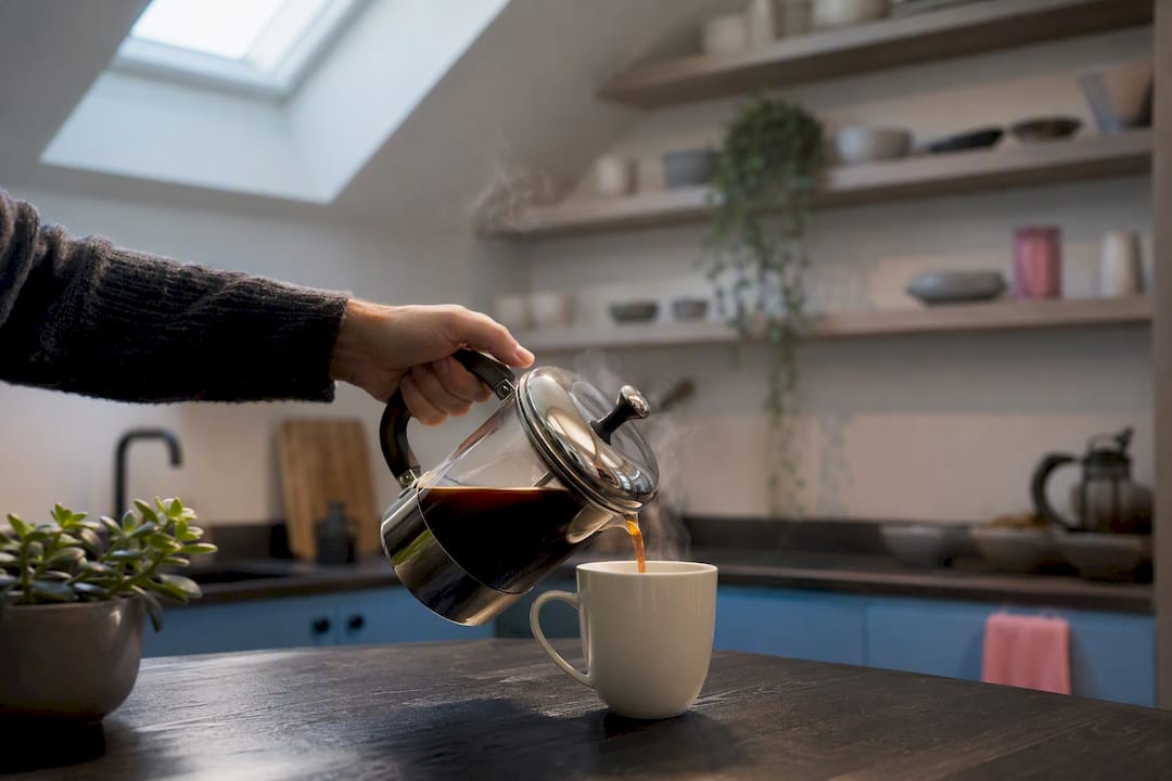 Hand pouring coffee into mug
