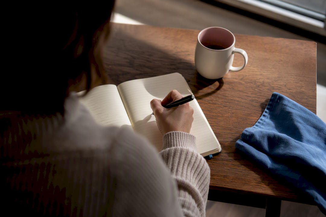 Hand writing a compassionate journal entry