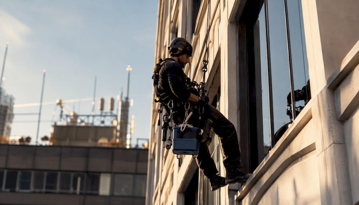 Rope access window cleaner descending façade