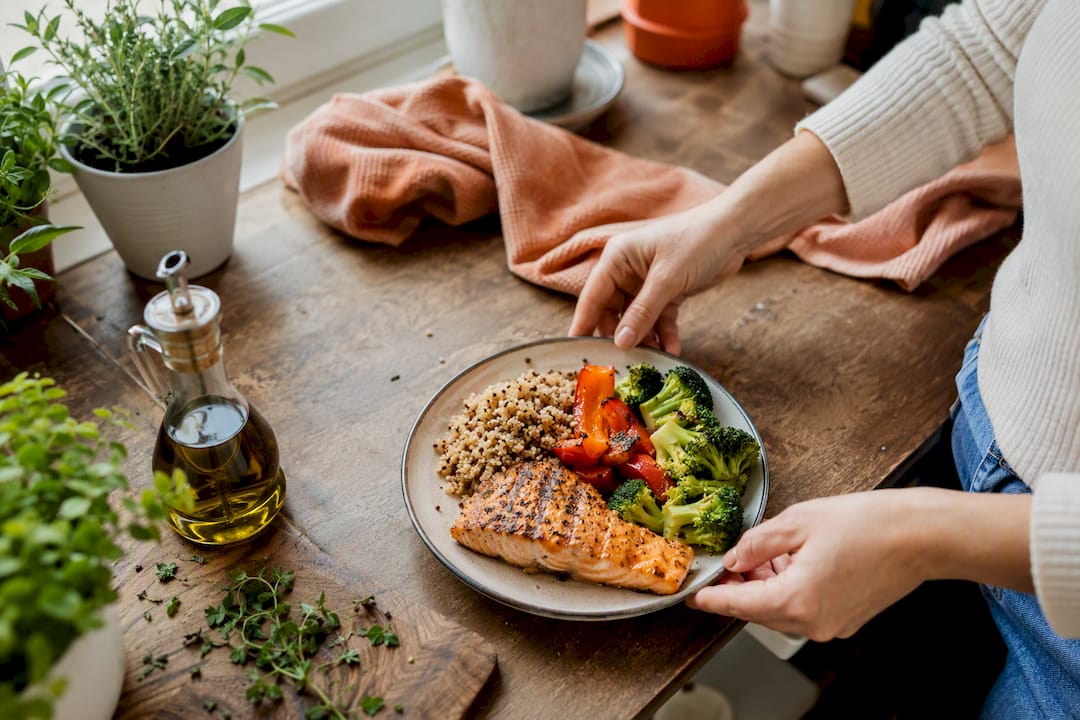 Hands arranging balanced heart-healthy dinner plate