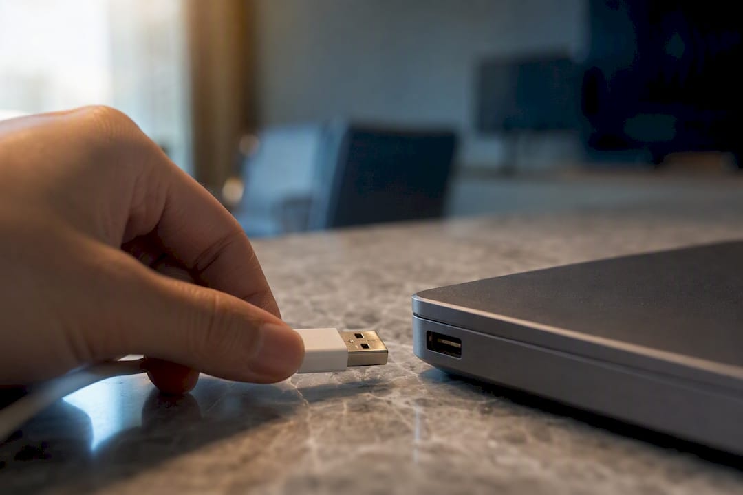 Hand hält USB-Kabel neben alten USB-Anschluss