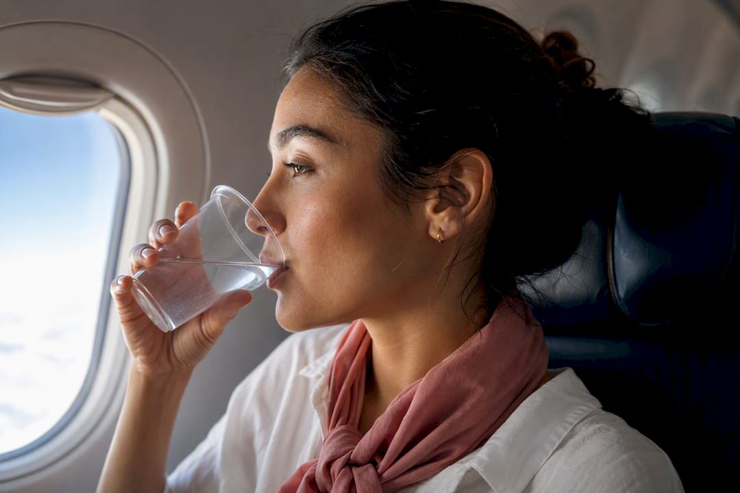 Traveler drinking water during flight
