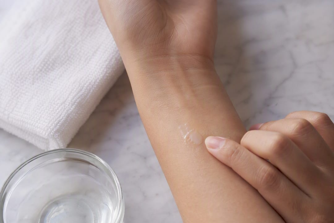 Fingertip applying skincare patch test