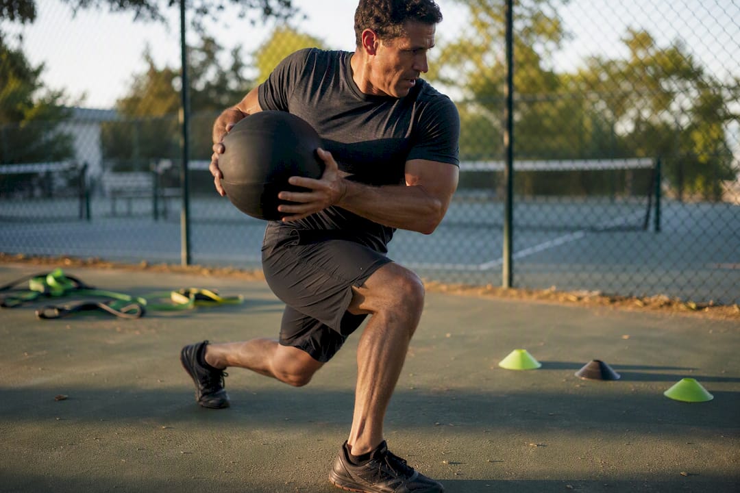 Athlete performing medicine ball rotational throw outdoors