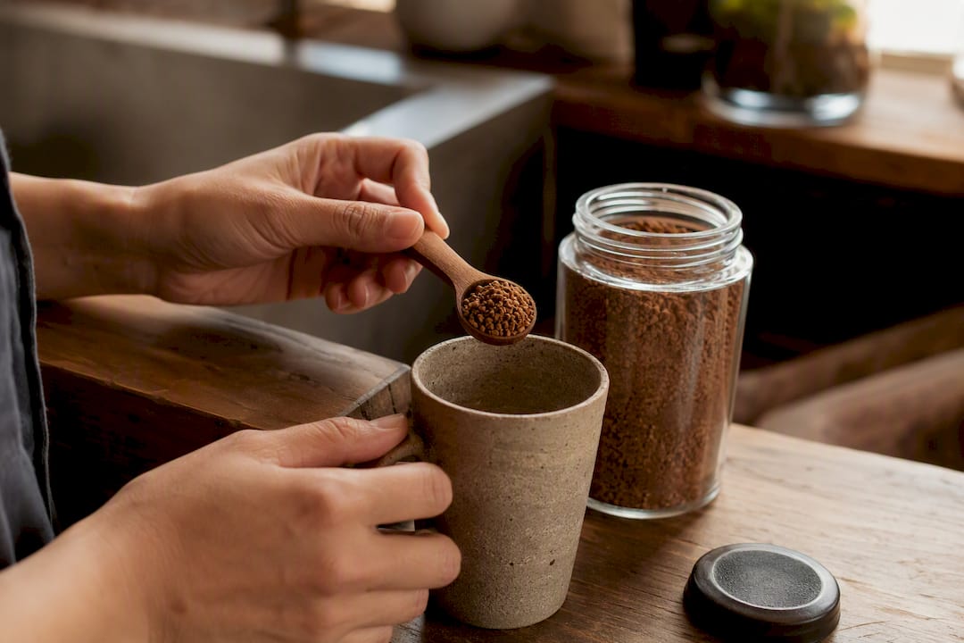 Hands measuring instant coffee powder carefully