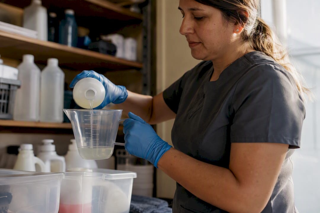 Cleaning staff using gloves and eye protection handling disinfectants