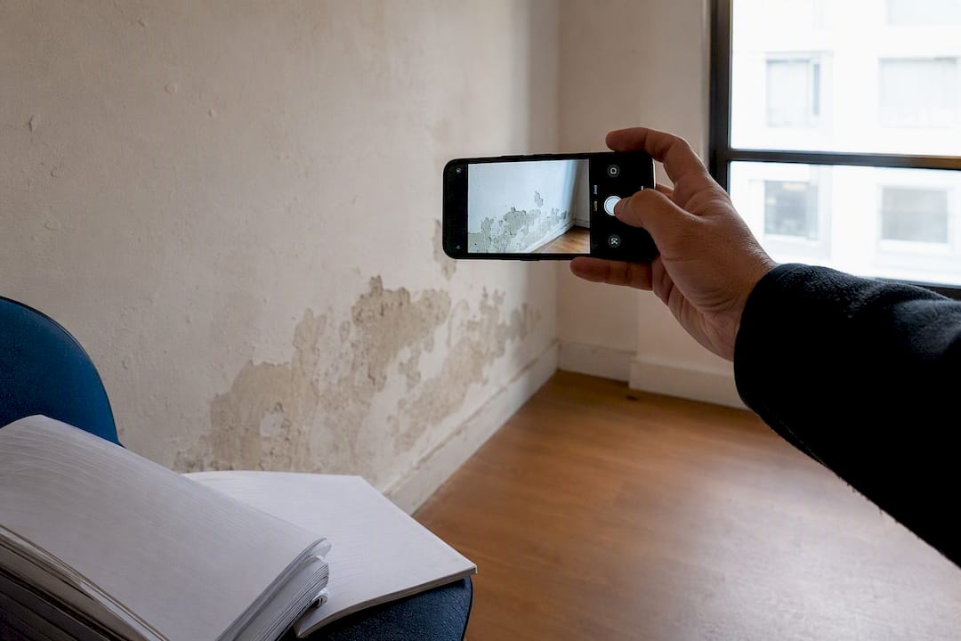 Inquilino sacando fotos a la pared del piso