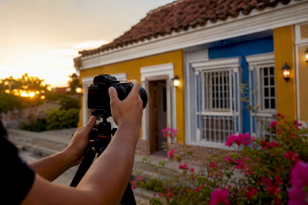 Fotógrafo ajustando la cámara para fotografiar una casa