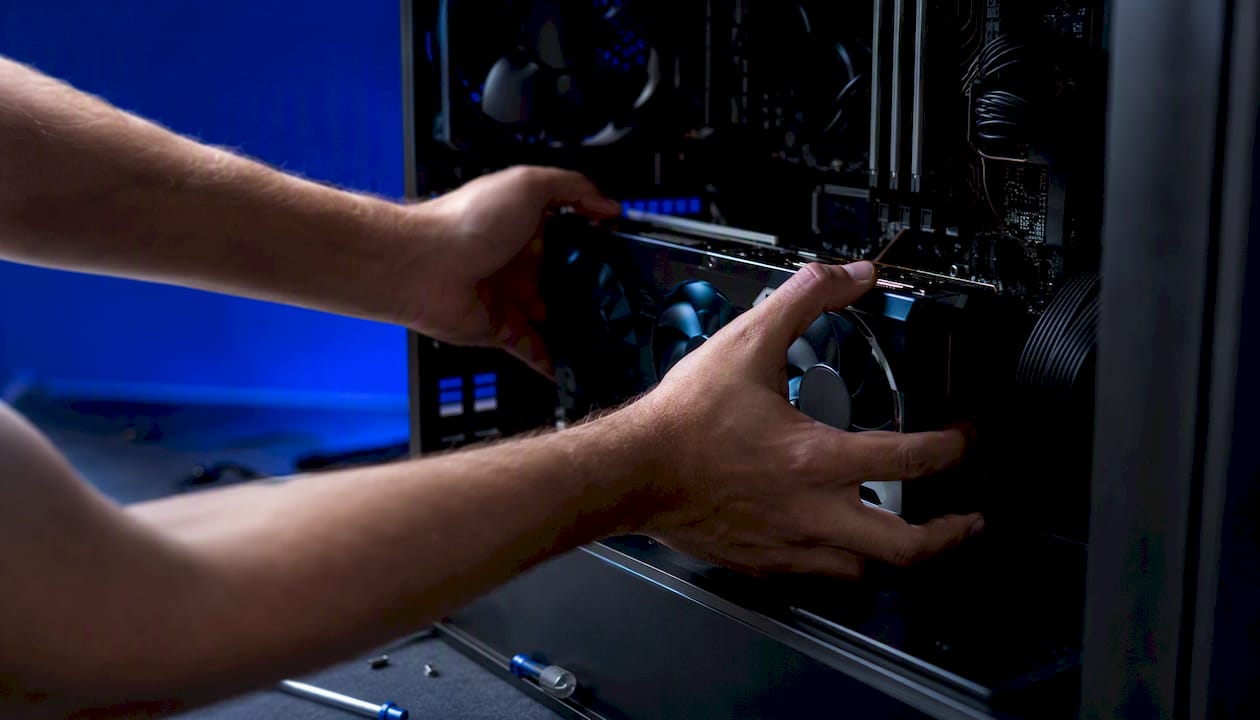 Hands installing RAM module on motherboard