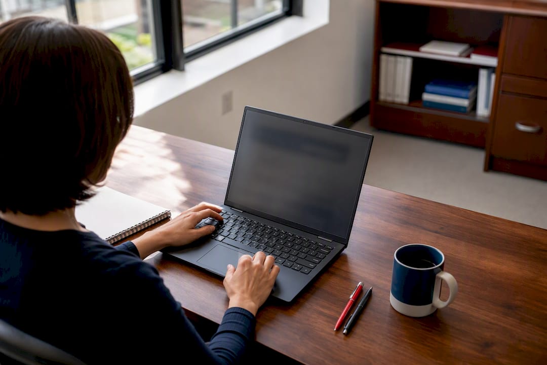 Hands navigating supplier catalogue on laptop