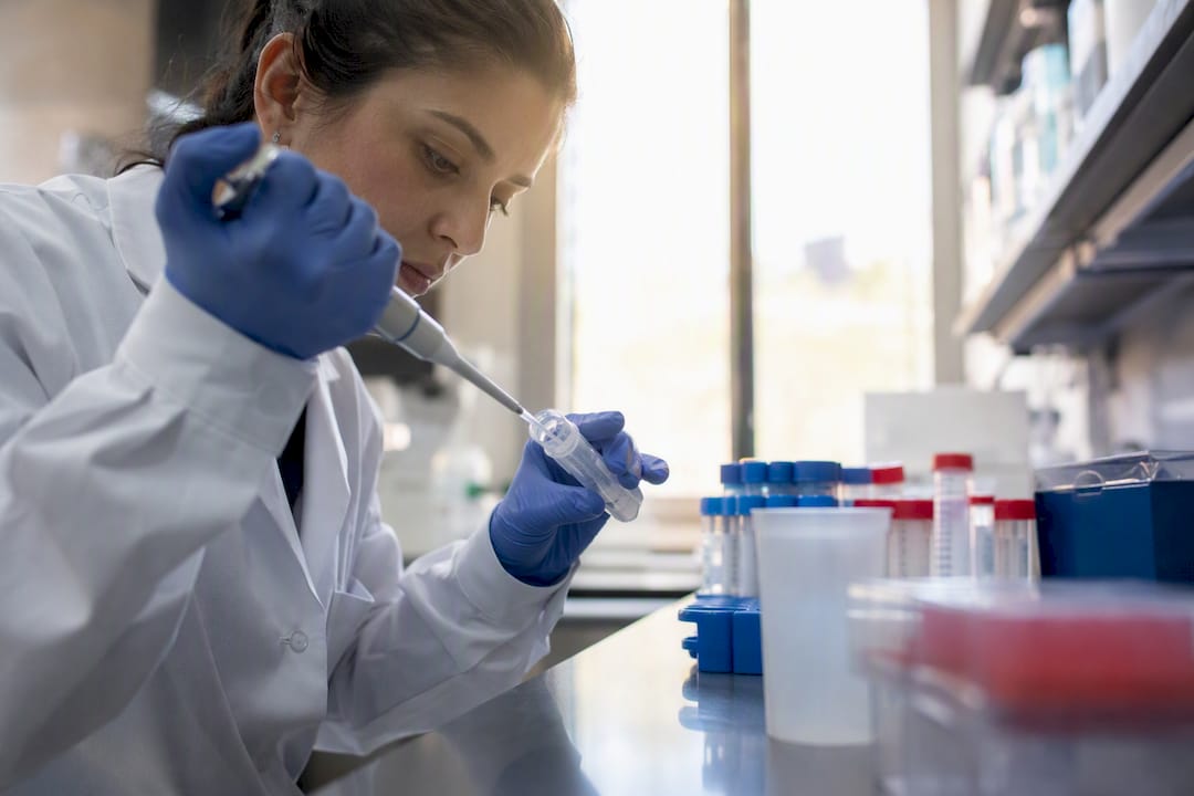 Scientist pipetting antibody reagent in lab