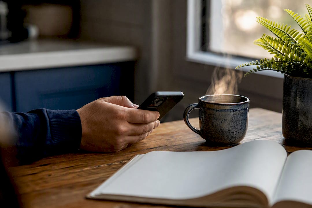 Agent's hand near smartphone and coffee cup