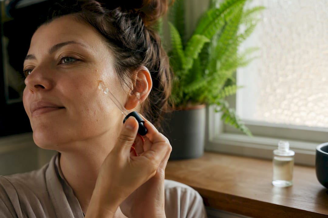 Hands gently applying serum to face