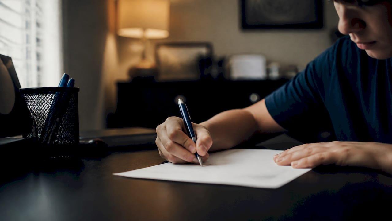 Student's hand writing on worksheet