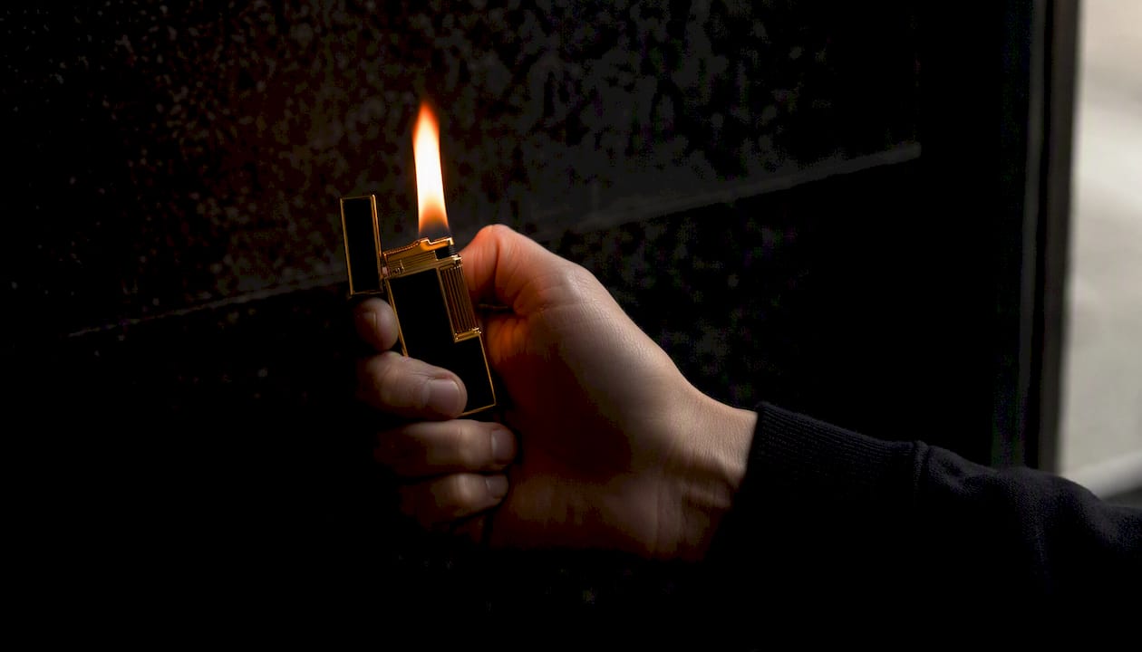 Hand igniting lighter flame close-up