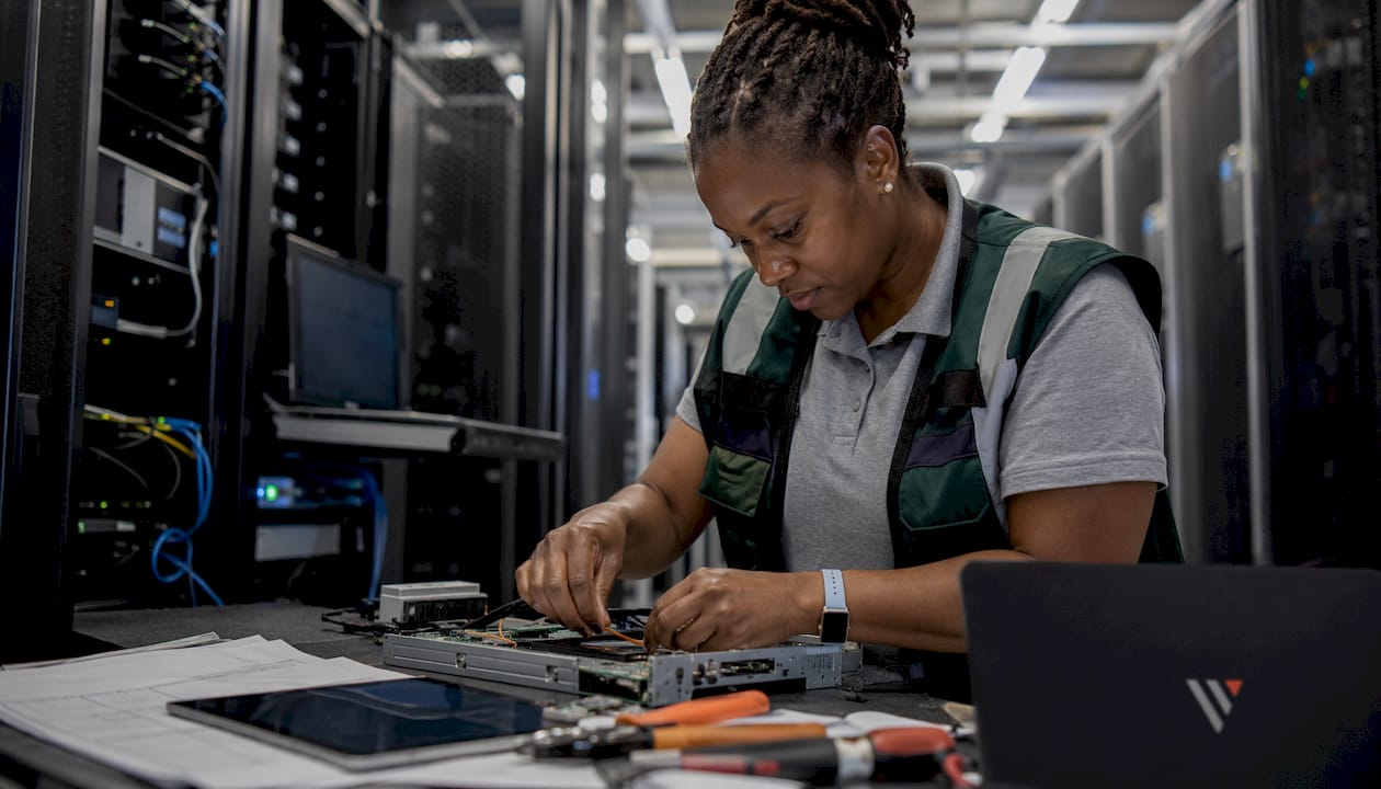 Technician inspecting hardware in data center