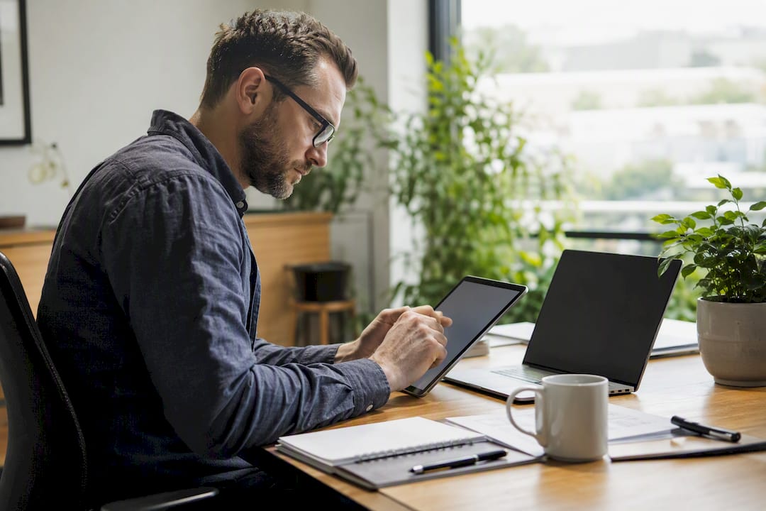 Hands reviewing audit reports with dark laptop