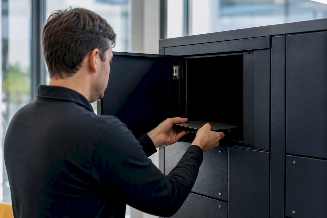 Hands placing device into IT locker compartment