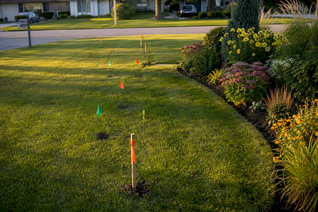 Survey stakes and flags marking lawn boundaries